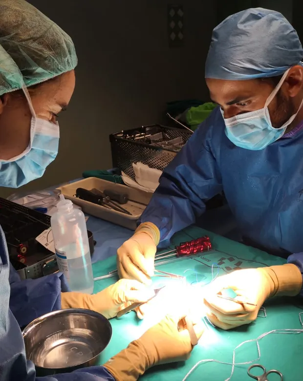 Dr Aveledo operating on a shoulder in theatre, alongside a scrub nurse